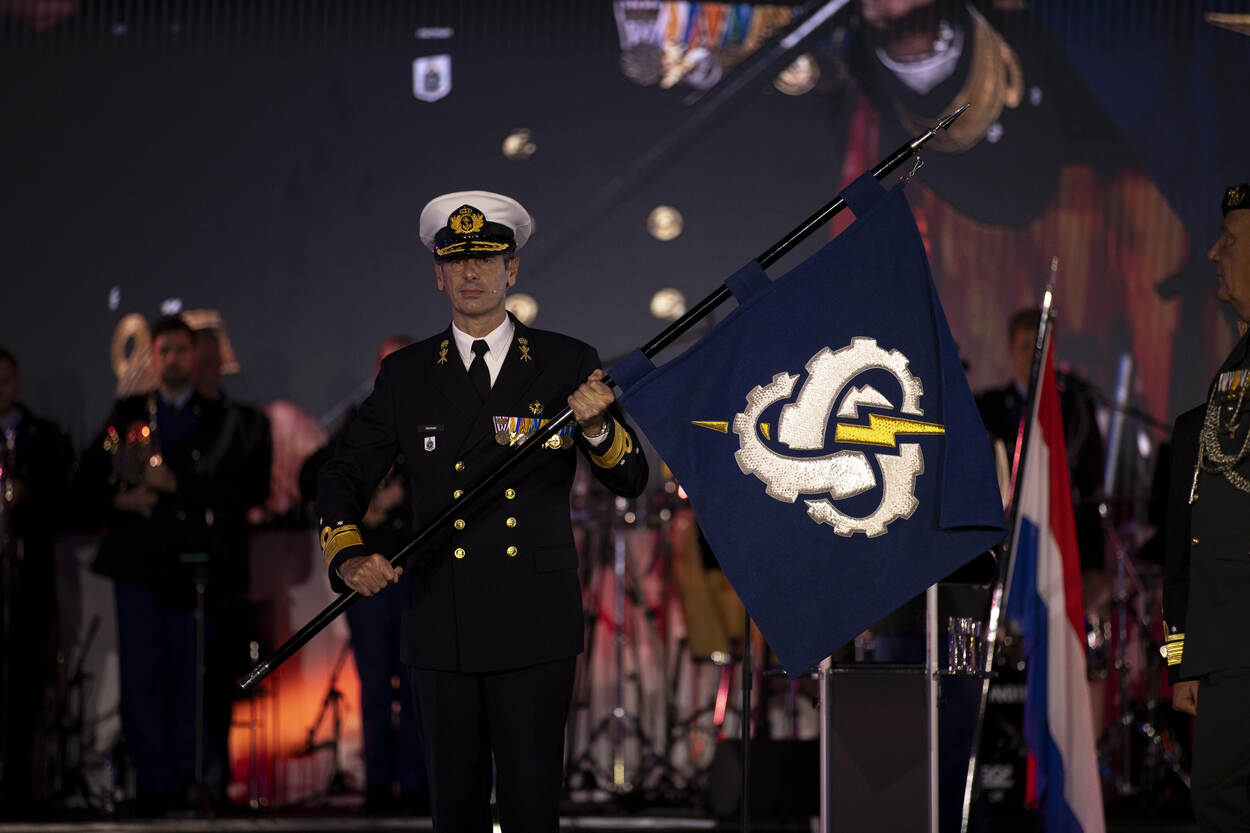 Vice-admiraal Jan Willem Hartman met de eenheidsvlag van COMMIT in zijn handen.