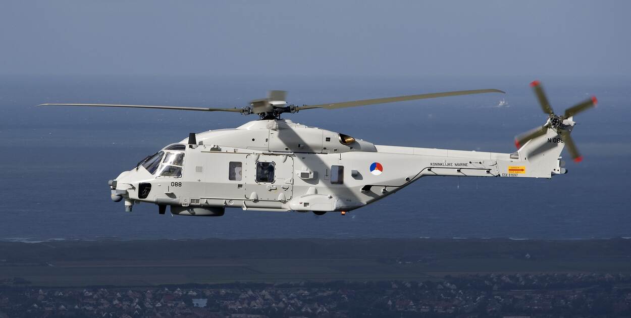 Linker zijkant van de NH90 boven Nederlands poldergebied aan de kust.