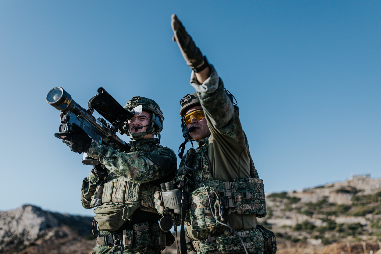 Een schutter richt de infrarood-zoekkop van de Stinger op een doel. Een instructeur wijst naar het doel.