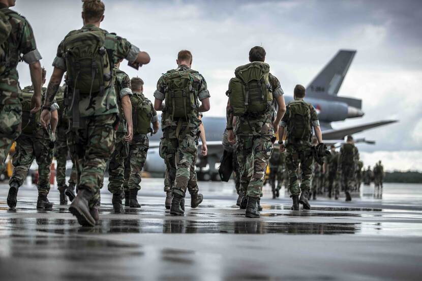 Militairen lopen naar militair vliegtuig op Vliegbasis Eindhoven