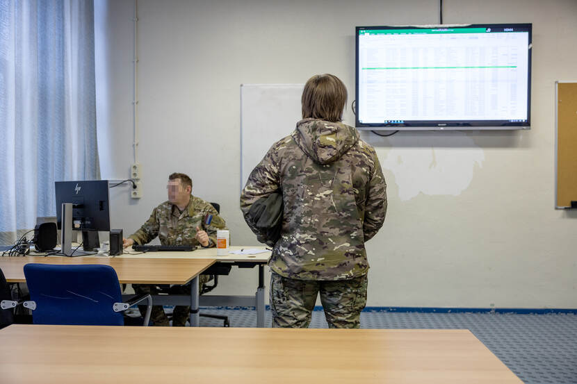 Een sergeant-majoor van personeelszaken controleert de gegevens.