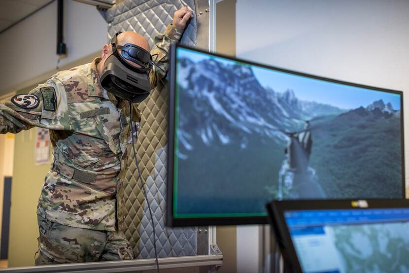 Een militair draagt een VR-bril en waant zich hierdoor in een vliegtuig.