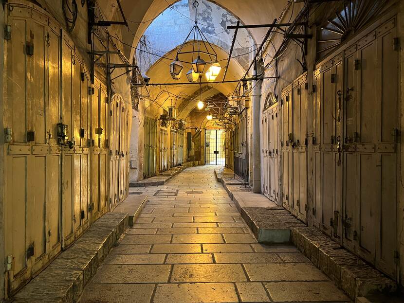 Een doorkijkje in een willekeurige, verlaten winkelstraat in Jeruzalem, waar alle deuren van de winkels gesloten zijn.