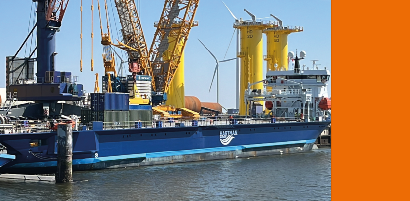 Blauw schip in de haven met enkele containers op het dek.