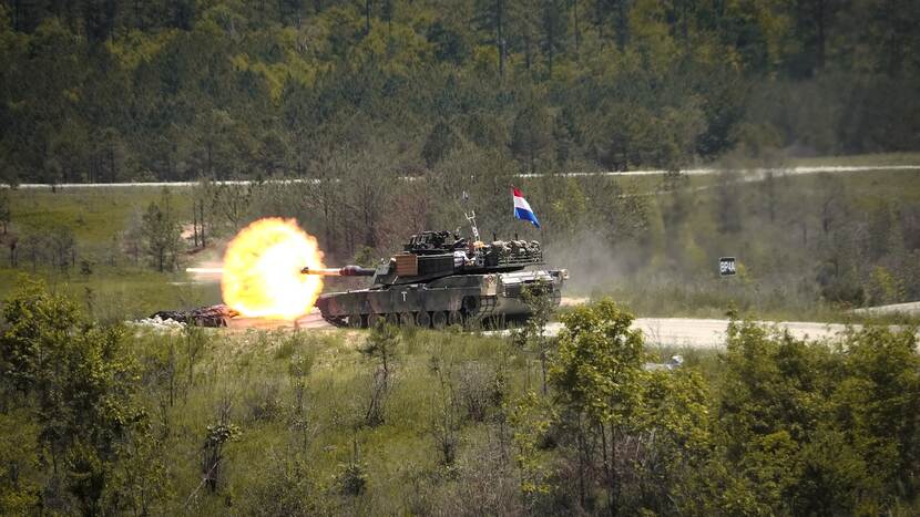 Een Abramstank met achterop de Nederlandse vlag vuurt op het schietterrein van Fort Moore.