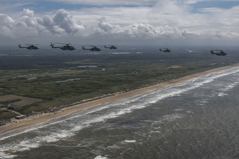 De acht NH90’s vliegen boven zee.