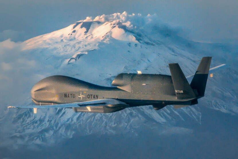 Een RQ-4 Global Hawk vliegt langs de besneeuwde toppen van de vulkaan Etna