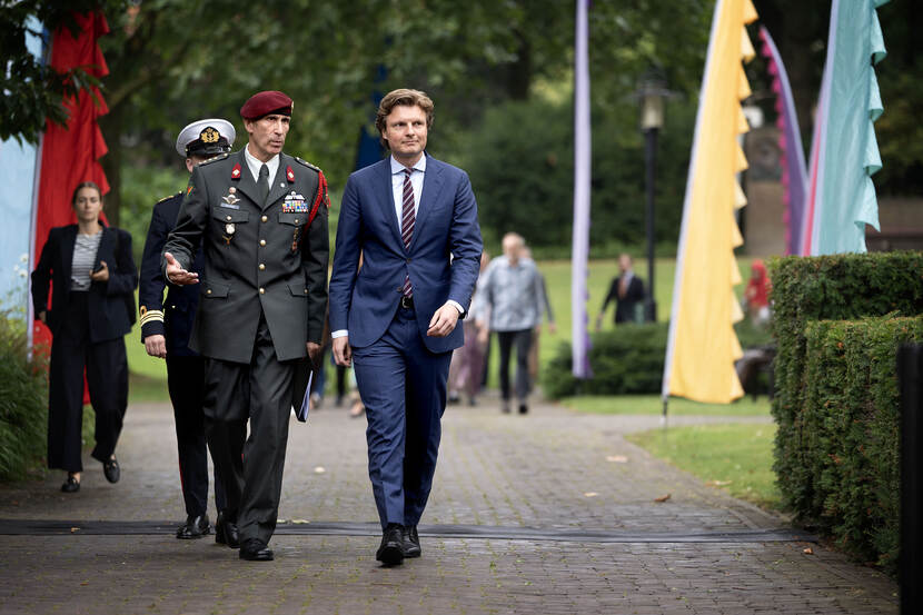 De commandant Bronbeek kolonel Gerard van Kuijck en defensieminister Ruben Brekelmans wandelen naast elkaar over het terrein van Bronbeek.