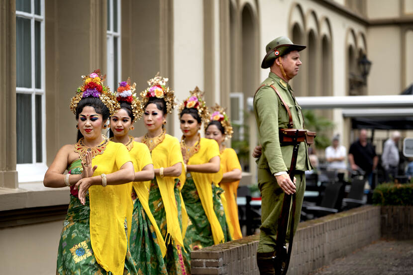 Twee ‘militairen’ in het historisch uniform van Heutsz staan op wacht terwijl een traditionele dans plaats heeft. Onder de toeschouwers onder meer vier bewoners van Bronbeek.