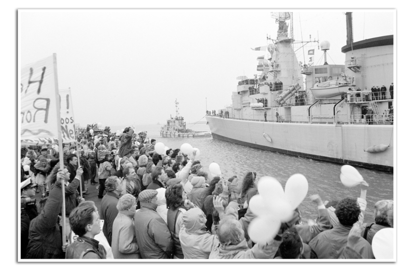 De Witte de With met daarvoor een sleepboot wordt bij terugkeer begroet door familie en vrienden in de haven van Den Helder.