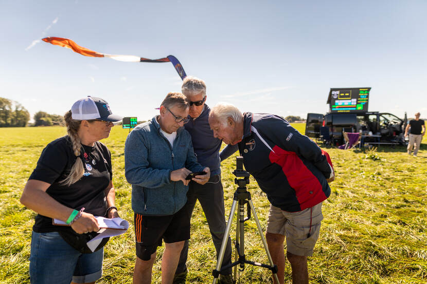 Een groep staat bij het kussen en analyseert de gegevens na een landing van parachutisten.