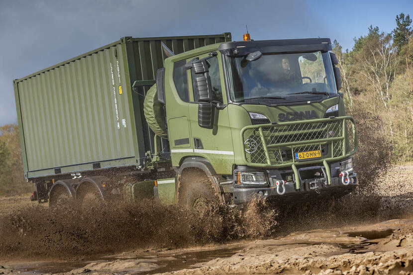 Een Scania rijdt door de modder.