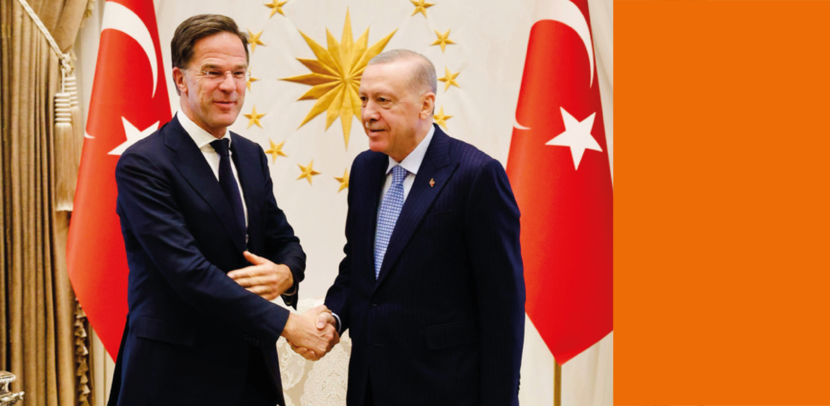 Rutte en Erdogan schudden elkaar de hand met op de achtergrond 2 Turkse vlaggen