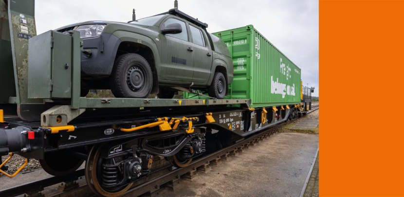 Een containerwagon van Defensie. Erop staat een voertuig en een container.