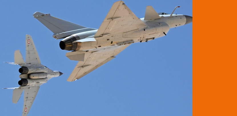 Een Egyptische MiG-29M (links) zwenkt weg naar links, terwijl een Chinese J-10 doorvliegt.