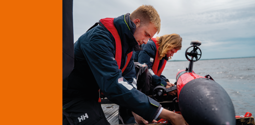 2 mensen met zwemvest zitten aan een onderwaterdrone.
