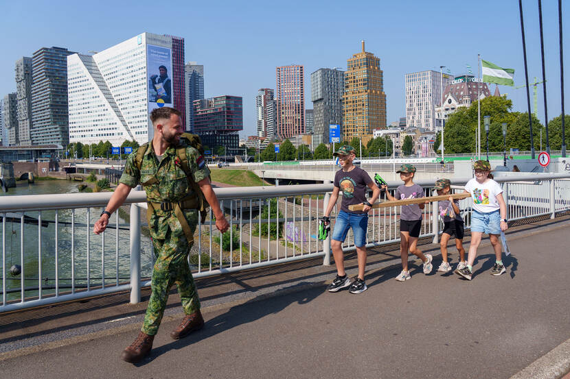 Kinderen lopen met een balk over een brug