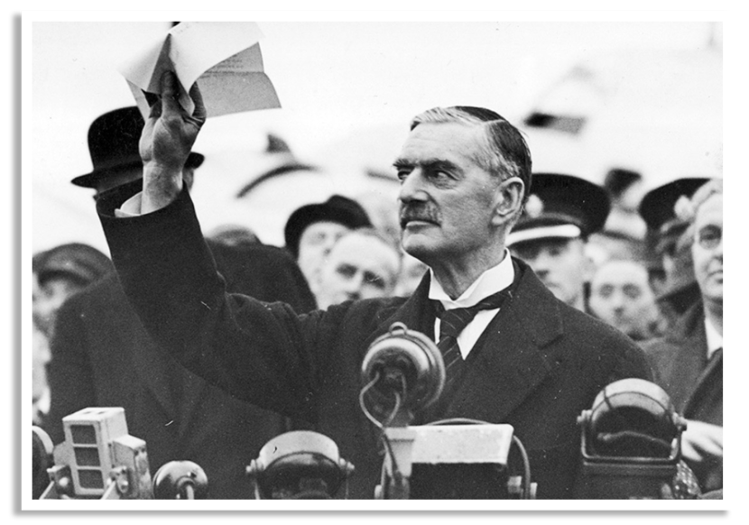 De Britse premier Neville Chamberlain toont bij terugkeer in Engeland het door Hitler en hemzelf ondertekende Verdrag van München.