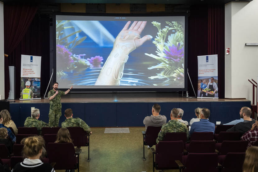 Militair spreekt zaal toe tijdens presentatie