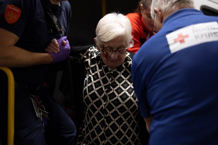 Medisch personeel helpt een oude vrouw.