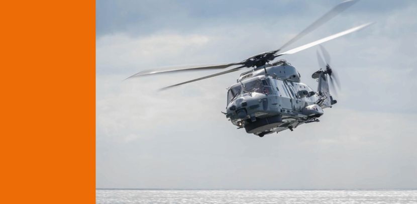 Een helikopter vliegt boven de zee.