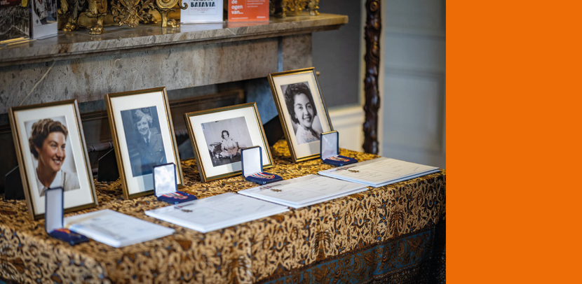 4 foto’s van vrouwen staan in fotolijsten op een tafel.