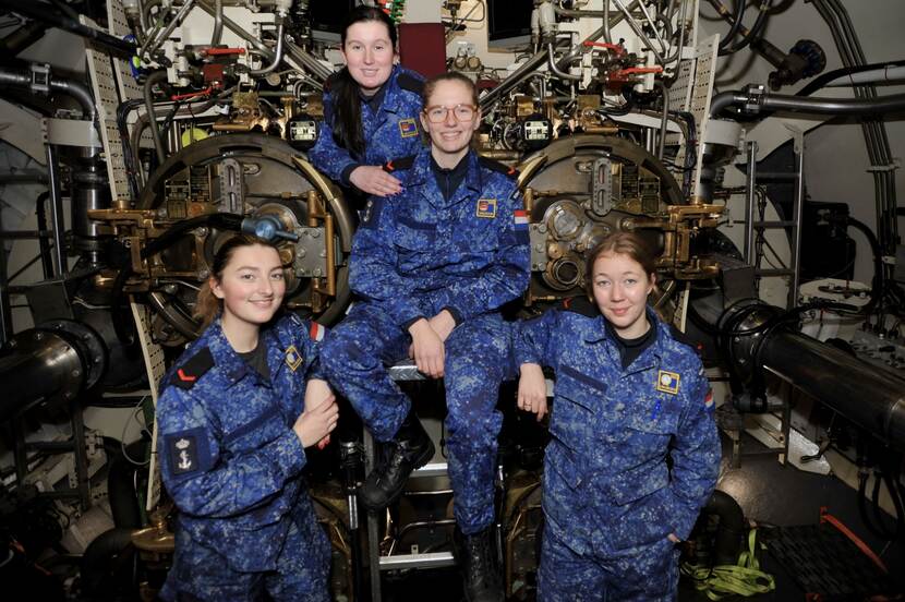 Foto van 4 jonge matrozen die hebben gekozen voor de onderzeedienst in de torpedokamer.