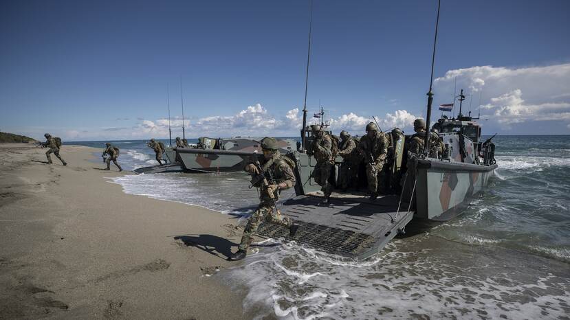 Mariniers rennen vanaf een landingsvaartuig het strand op.