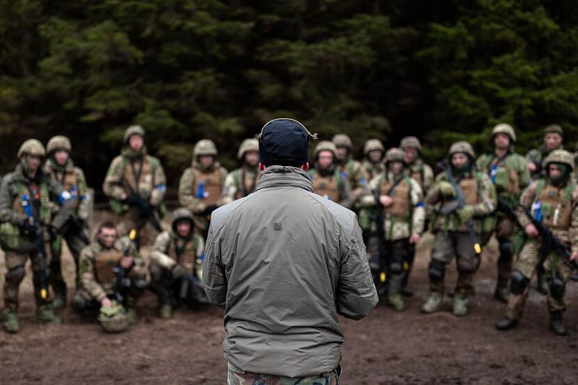 Een Nederlandse marinier spreekt Oekraïense militairen-in-opleiding toe.