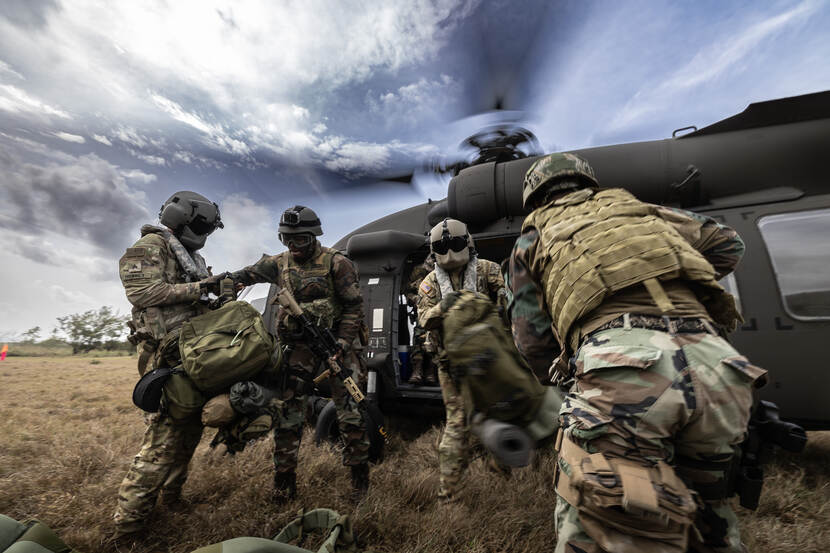 Militairen stappen in een Blackhawk-helikopter.