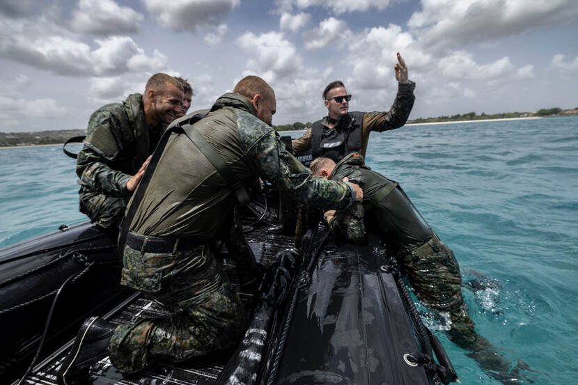 Mariniers worden uit zee gehaald door collega’s met een boot.