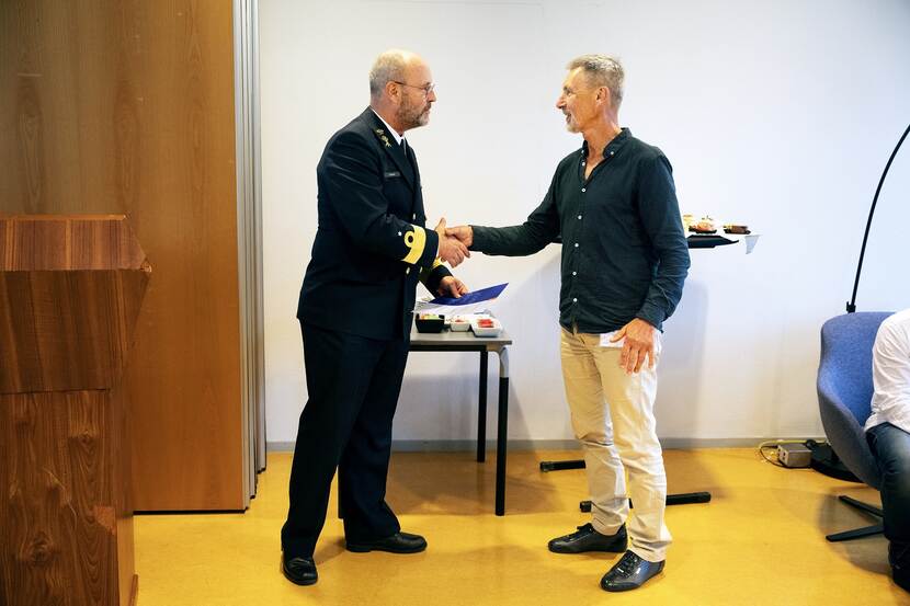 Commandeur Jeroen Hodes schudt de hand van Ton Stavenuiter.