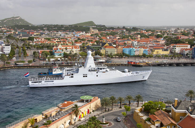 Een marineschip vaart de baai bij Willemstad, Curaçao, binnen.