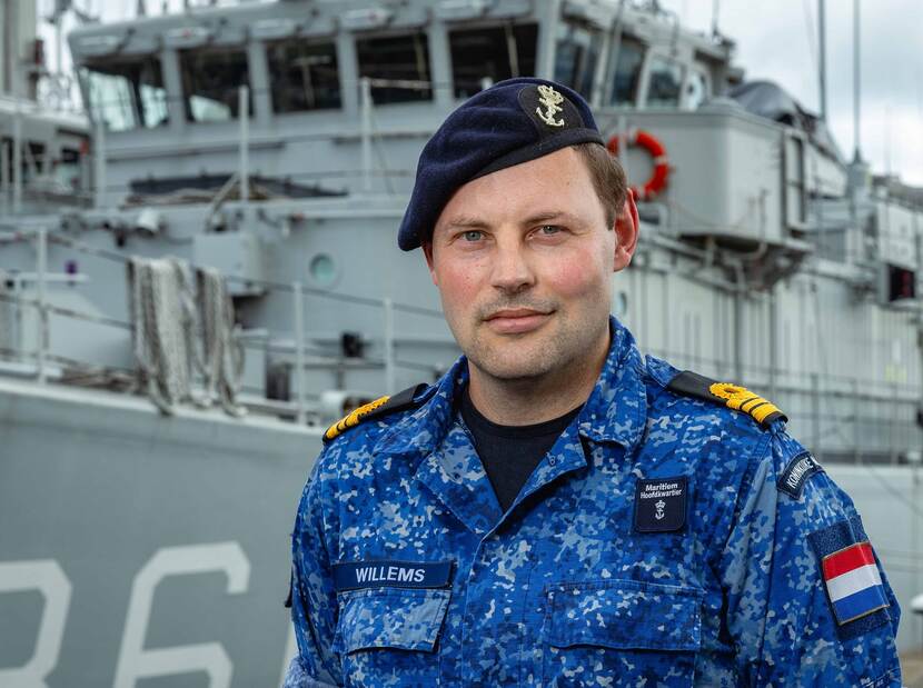 Luitenant ter zee 1 Ludo Willems staand voor een uit dienst getelde mijnenjager in de haven van Den Helder.