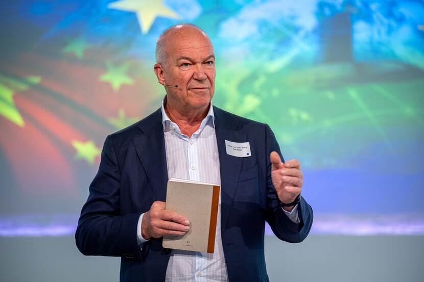 Hans van den Berg, de CEO Tata Steel spreekt tijdens conferentie en houdt notitieblok vast.