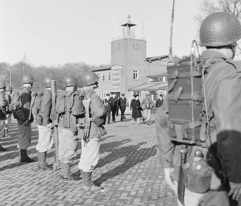 Mariniers staan opgesteld, koningin Juliana loopt voorbij.