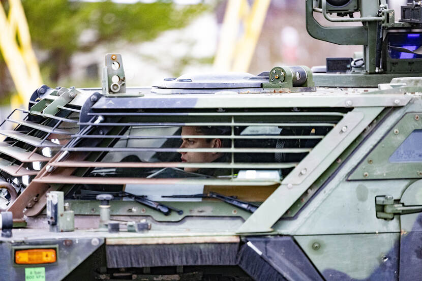 Een militair rijdt in een militair voertuig in Litouwen.