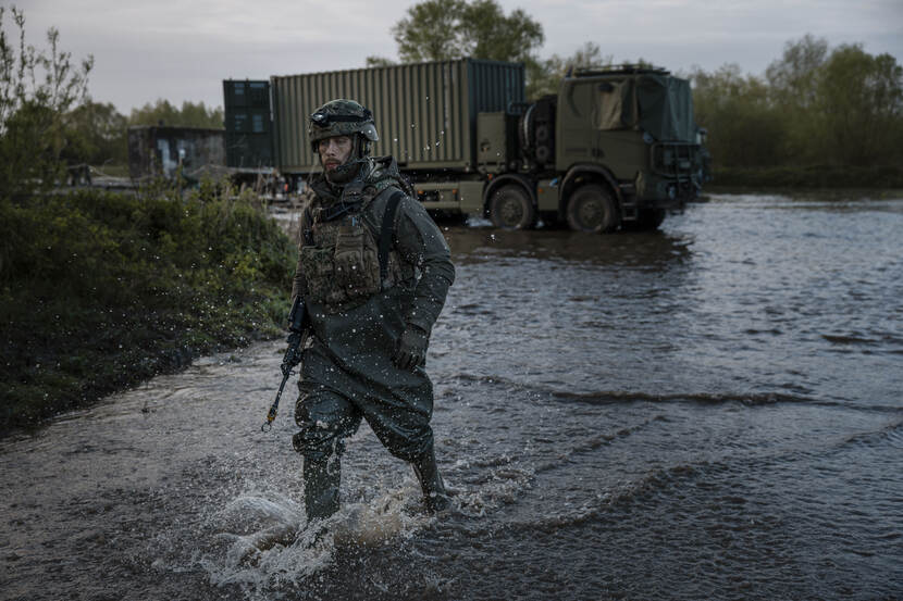 Een militair loopt door het hoge water.