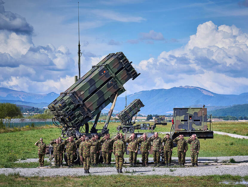 Militairen brengen de eregroet, staand voor een Patriot-wapensysteem tijdens de inzet in Slowakije in 2022.