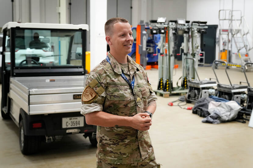 Sergeant der eerste klasse Ivo wijst op een elektrisch voertuig in de garage.