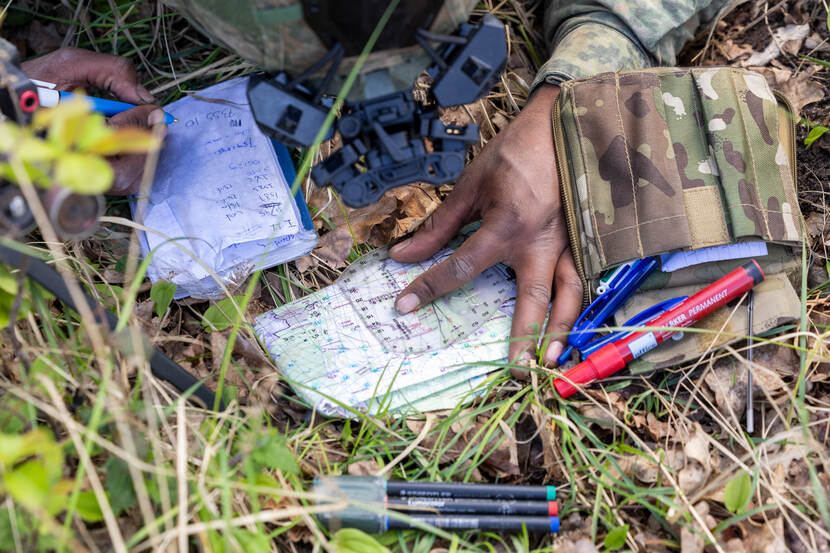 Een militair is druk met kaart, kompas en navigatie