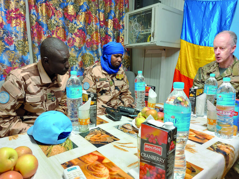 Militairen zitten om een tafel en bespreken de situatie.