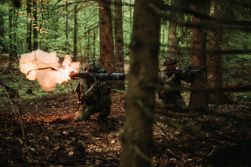 Twee militairen, een met een antitankwapen, de ander met het persoonlijk wapen, vuren op de zogenaamde vijand.