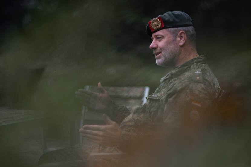 Militair half verborgen achter het struikgewas.