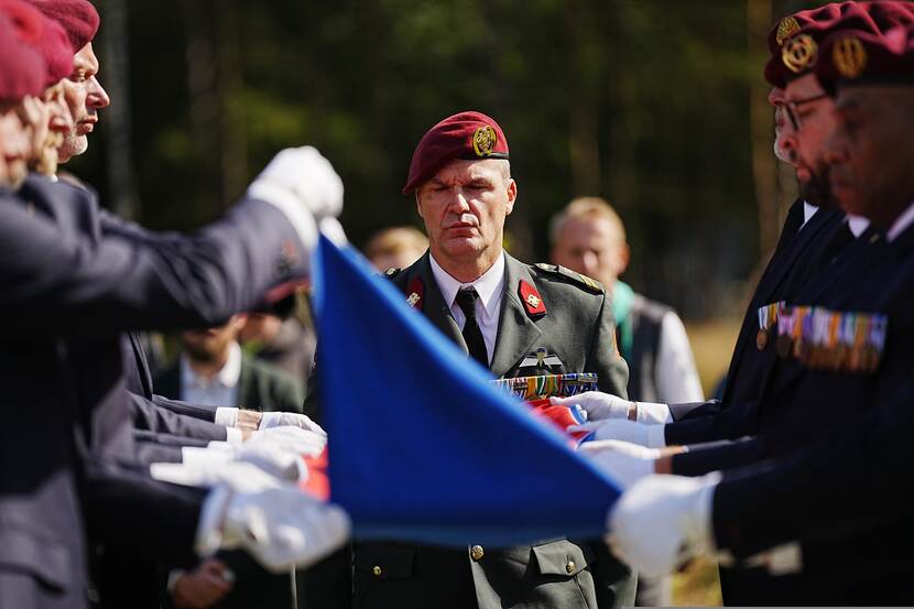 Het vouwen van de vlag op de kist wordt gadegeslagen door commandant draagploeg sergeant-majoor Patrick de Groot.