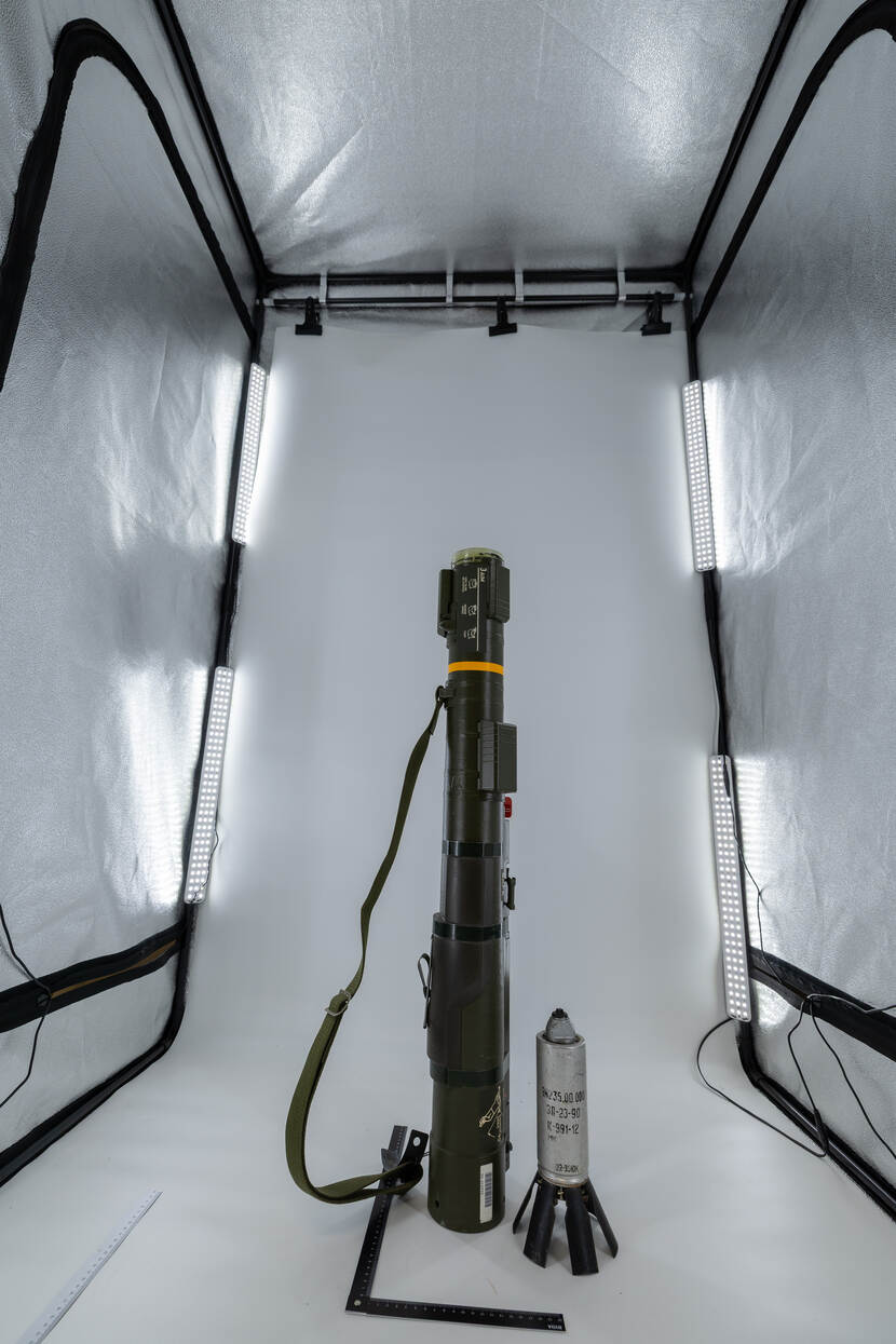 De fotostudio in de werkplaats, met daarin een wapensysteem en een munitieartikel.