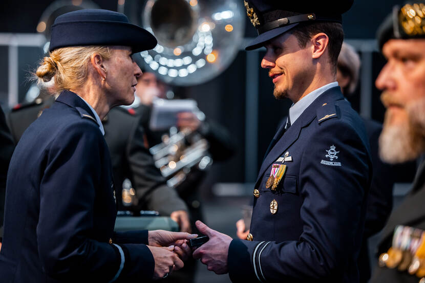 Commodore Ellen Scholten overhandigt een medaille aan een luchtmachtmilitair.