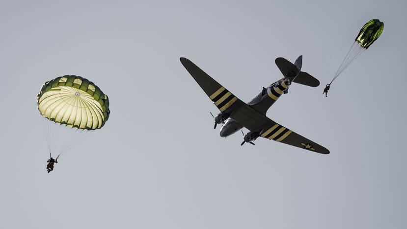 Parachutisten springen uit een historische C-47.