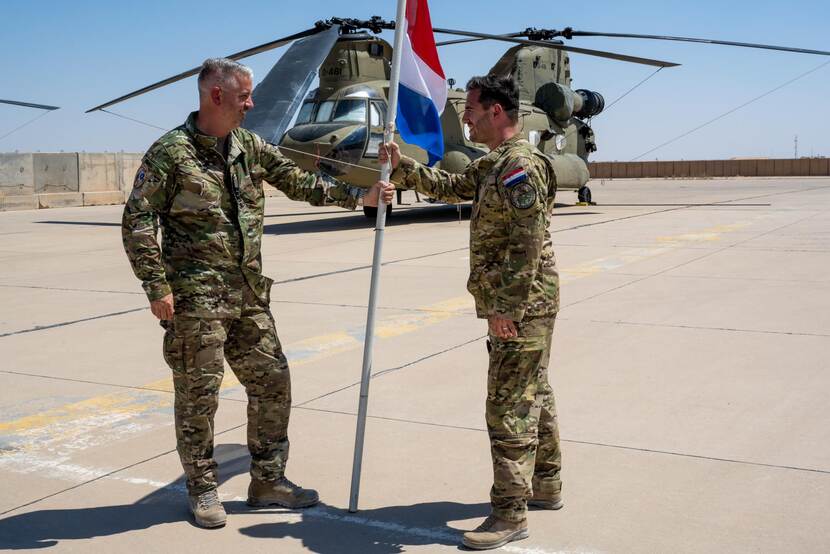 Overdracht van een vlag door twee luchtmachtmilitairen.