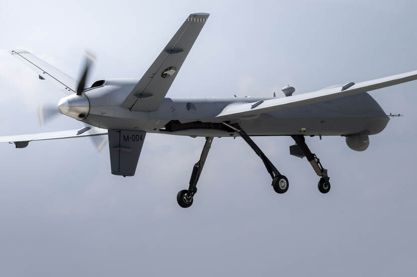 Een vliegende MQ-9 Reaper tegen een grijze lucht.